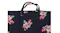 A close-up of a dark fabric tote bag with a pink and red floral pattern and two handles A close-up of a dark fabric tote bag with a pink and red floral pattern and two handles