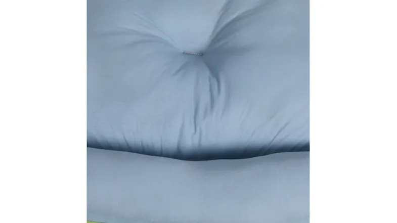 Close-up of a light blue cushioned fabric surface with a tufted centre and soft padded texture Close-up of a light blue cushioned fabric surface with a tufted centre and soft padded texture