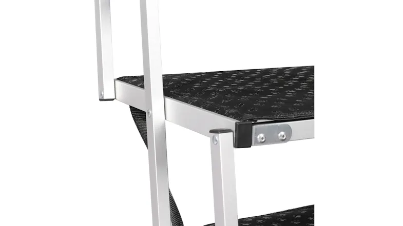 Close-up of folding metal pet stairs showing silver aluminum frames and black non-slip tread on the steps Close-up of folding metal pet stairs showing silver aluminum frames and black non-slip tread on the steps