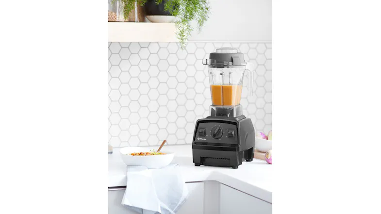 A Vitamix blender blending an orang juice A Vitamix blender blending an orang juice