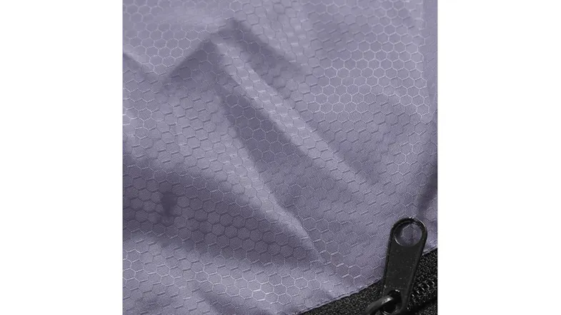 Close-up of textured purple fabric with a hex pattern and a black zipper pull Close-up of textured purple fabric with a hex pattern and a black zipper pull