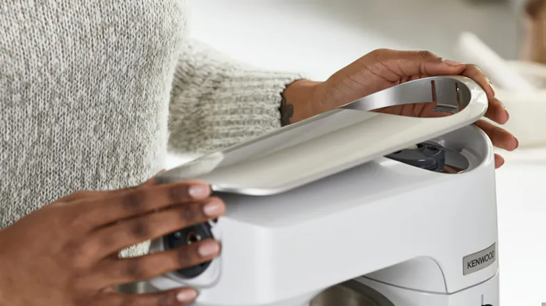 Hands lifting the top customisation panel from the Titanium Chef Baker XL to reveal the top‑cover design Hands lifting the top customisation panel from the Titanium Chef Baker XL to reveal the top‑cover design