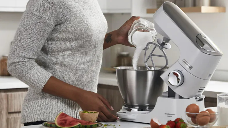Person pouring sugar into the bowl of the Kenwood Titanium Chef Baker XL while the K‑beater attachment is fitted Person pouring sugar into the bowl of the Kenwood Titanium Chef Baker XL while the K‑beater attachment is fitted