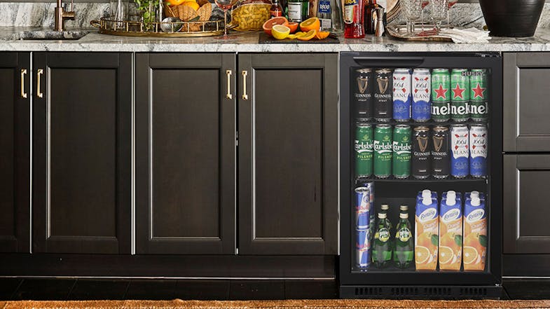 A kitchen setting with the Husky 90L bar fridge built into cabinetry, fully stocked with assorted drinks A kitchen setting with the Husky 90L bar fridge built into cabinetry, fully stocked with assorted drinks