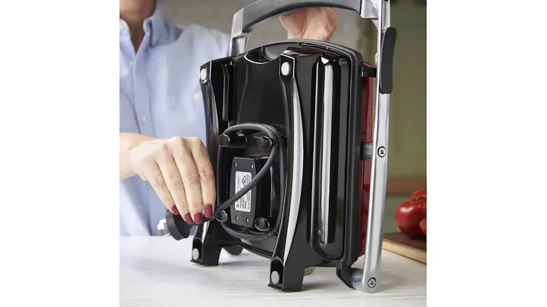 A person is wrapping the power cord around the base for upright storage A person is wrapping the power cord around the base for upright storage