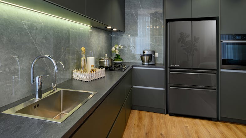 Wide-angle view of contemporary kitchen with a fridge in glass gunmetal finish, built into cabinetry Wide-angle view of contemporary kitchen with a fridge in glass gunmetal finish, built into cabinetry