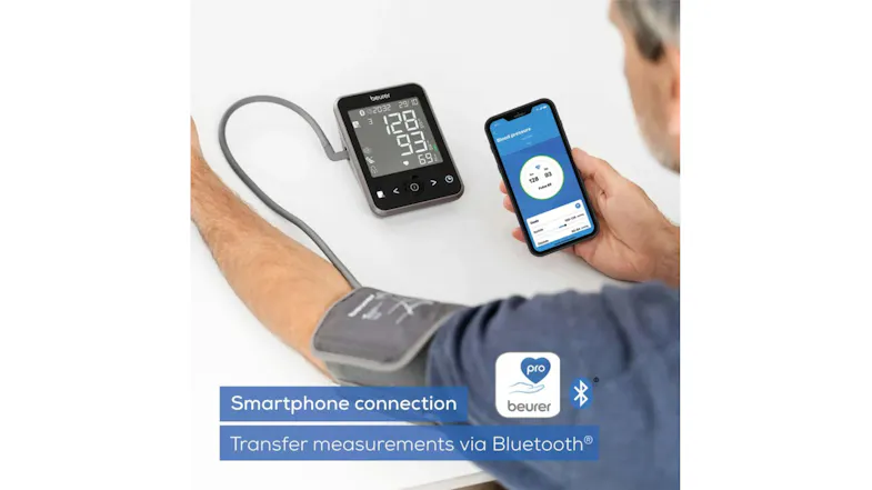 A man is connecting the blood pressure monitor to a smartphone app via Bluetooth A man is connecting the blood pressure monitor to a smartphone app via Bluetooth