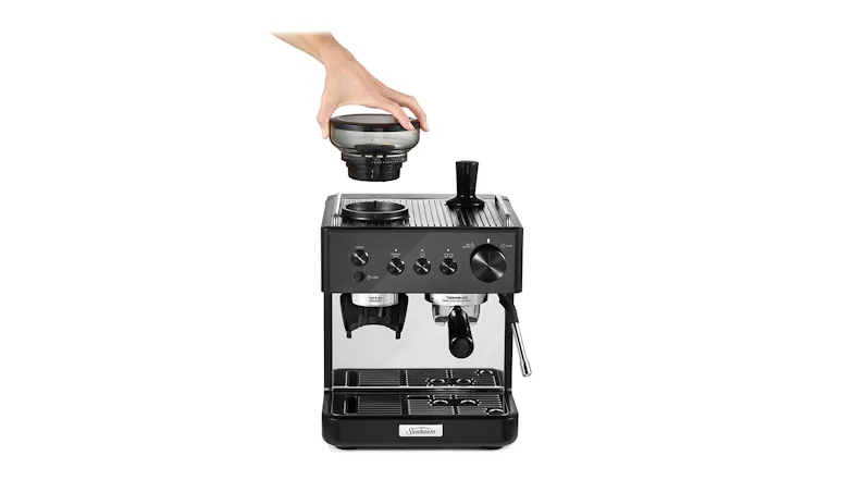 Hand placing grinder lid on Sunbeam Origins Classic manual espresso machine with steam wand and control knobs Hand placing grinder lid on Sunbeam Origins Classic manual espresso machine with steam wand and control knobs