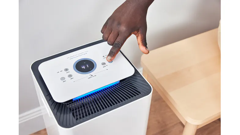 A hand pressing the touch controls on the dehumidifier’s top panel to adjust the settings A hand pressing the touch controls on the dehumidifier’s top panel to adjust the settings