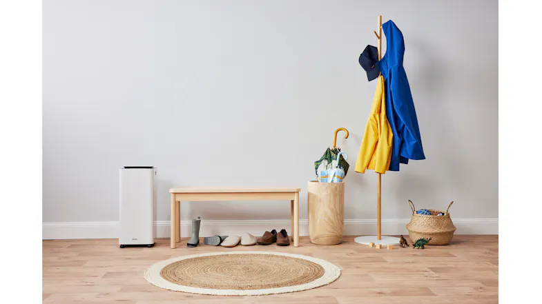 The dehumidifier is positioned in an entryway with a bench, shoes, coats, and umbrellas, demonstrating effective moisture control for high-traffic daily use areas The dehumidifier is positioned in an entryway with a bench, shoes, coats, and umbrellas, demonstrating effective moisture control for high-traffic daily use areas