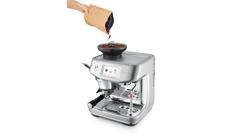 A person pours coffee beans into the grinder hopper. A person pours coffee beans into the grinder hopper.
