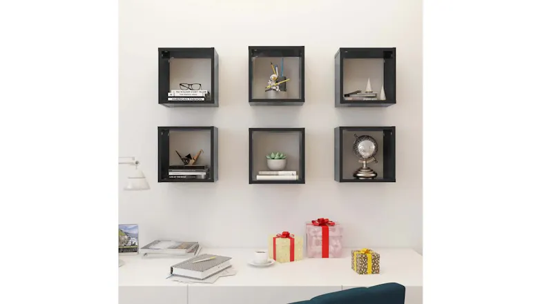 Six black cube shelves are mounted in a grid on a white wall above a desk with decorative objects Six black cube shelves are mounted in a grid on a white wall above a desk with decorative objects