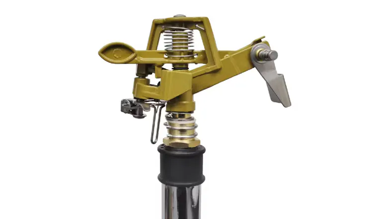 Close-up of a brass-coloured metal impulse NNEVL sprinkler head, showing visible springs and adjustable mechanical components Close-up of a brass-coloured metal impulse NNEVL sprinkler head, showing visible springs and adjustable mechanical components