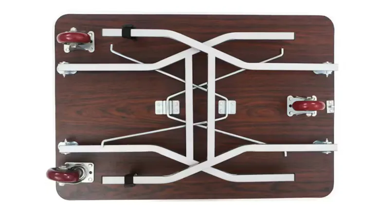 Underside view of the table showing crossed white metal support bars, locking brackets, and four wheels mounted. Underside view of the table showing crossed white metal support bars, locking brackets, and four wheels mounted.