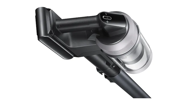 A close-up of a cordless stick vacuum showing the handle, clear dust canister, and long extension wand A close-up of a cordless stick vacuum showing the handle, clear dust canister, and long extension wand