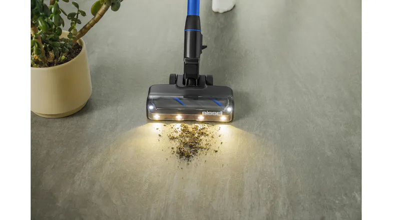 A vacuum removing scattered litter near a cat litter box on tiled flooring in a pet care area A vacuum removing scattered litter near a cat litter box on tiled flooring in a pet care area