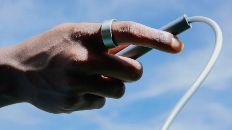 Hand holding a jump rope handle with a smart ring on a finger Hand holding a jump rope handle with a smart ring on a finger