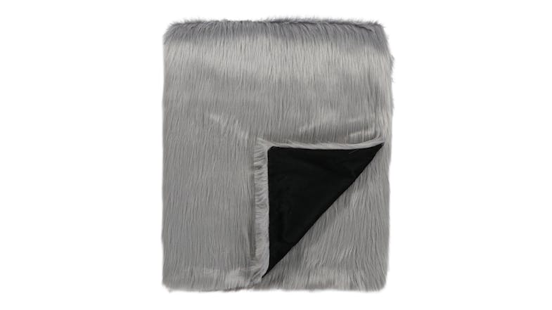 A silver grey faux fur blanket with a black underside, partially folded to show the contrasting inner lining A silver grey faux fur blanket with a black underside, partially folded to show the contrasting inner lining