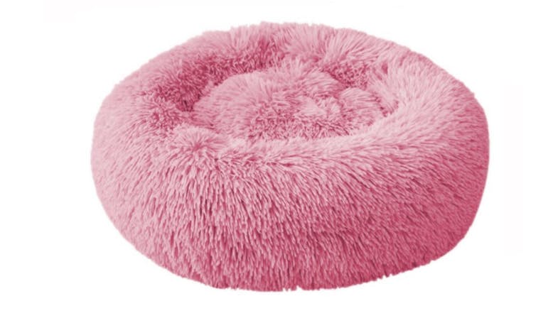 A round, fluffy, pink pet bed designed for small animals like cats or dogs. A round, fluffy, pink pet bed designed for small animals like cats or dogs.