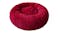 A round, fluffy, red pet bed designed for small animals like cats or dogs. A round, fluffy, red pet bed designed for small animals like cats or dogs.