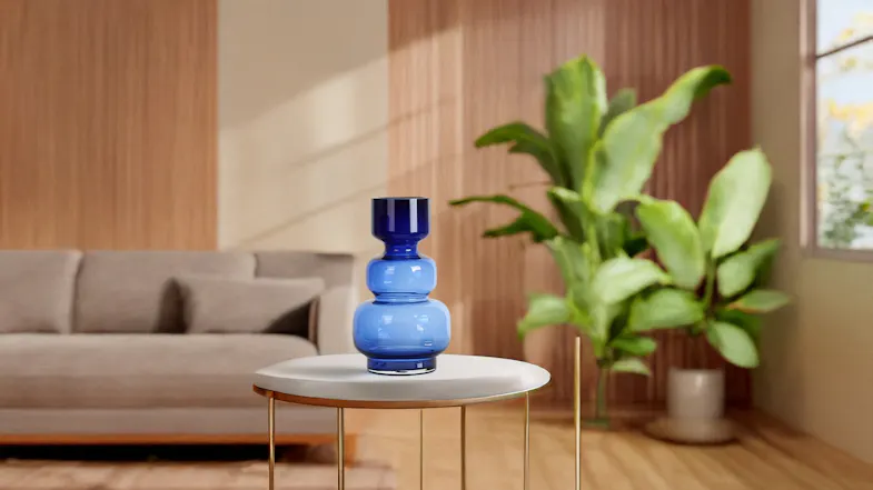 A tall, three-tiered blue glass vase sits on a table in a modern living room A tall, three-tiered blue glass vase sits on a table in a modern living room
