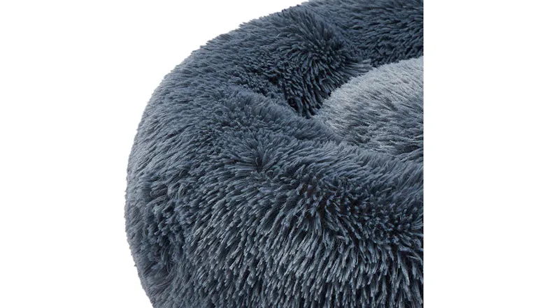 A blue, round, plush pet bed with a soft, fluffy texture. A blue, round, plush pet bed with a soft, fluffy texture.