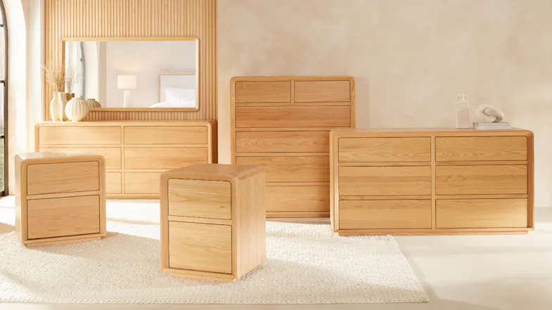 A stylish wooden-framed mirror shown as part of a wooden bedroom dresser set A stylish wooden-framed mirror shown as part of a wooden bedroom dresser set