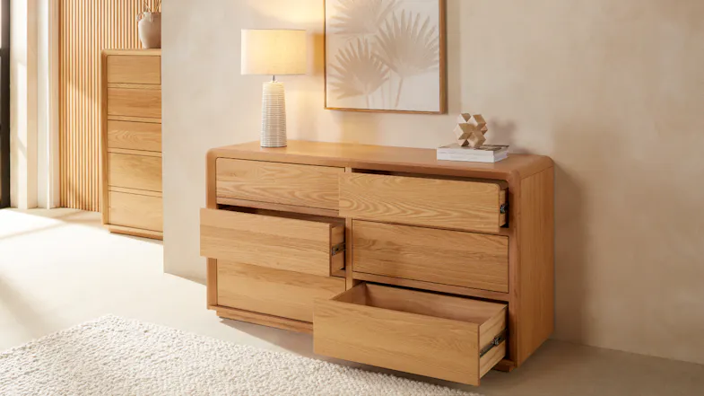 A 6-drawer lowboy dresser with three drawers open. A 6-drawer lowboy dresser with three drawers open.