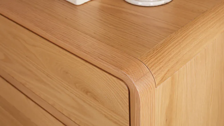 A close-up of a small lowboy, showing its smooth, rounded corner. A close-up of a small lowboy, showing its smooth, rounded corner.