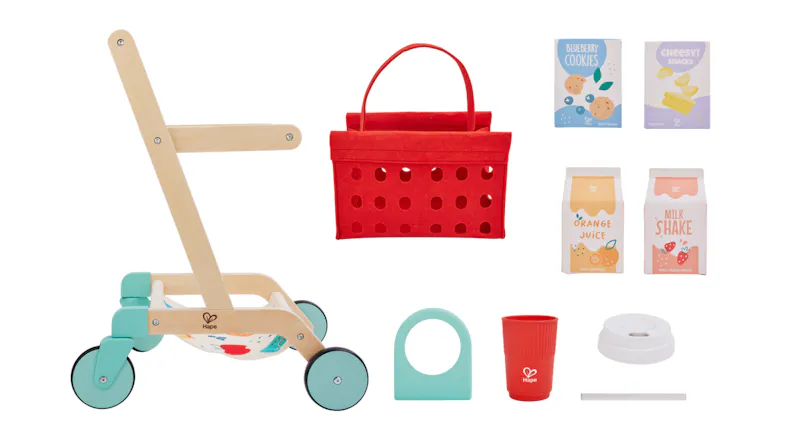 A wooden shopping cart is surrounded by toy grocery items. A wooden shopping cart is surrounded by toy grocery items.