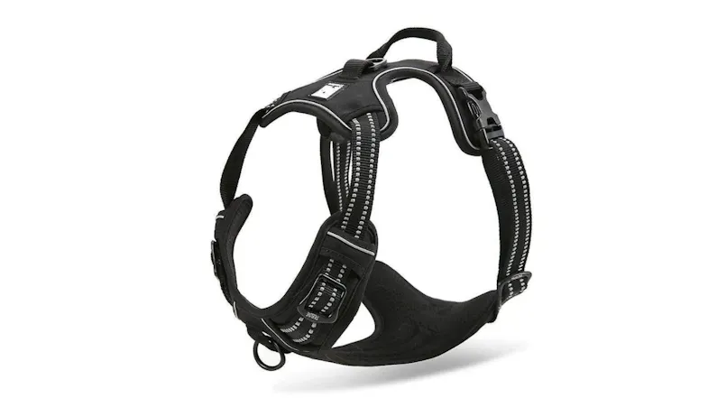 A black dog harness with reflective stitching, adjustable straps, a top handle, and a black plastic buckle. A black dog harness with reflective stitching, adjustable straps, a top handle, and a black plastic buckle.