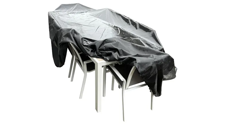 A view of a white dining set with a black outdoor furniture cover A view of a white dining set with a black outdoor furniture cover