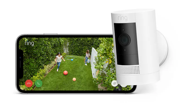 A view of a wall-mounted Ring camera and a smartphone that shows a live feed of kids playing in a backyard A view of a wall-mounted Ring camera and a smartphone that shows a live feed of kids playing in a backyard