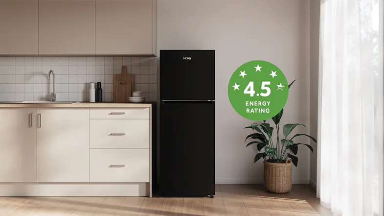 The Haier top-freezer fridge in a minimalist kitchen with a 4.5 energy rating label The Haier top-freezer fridge in a minimalist kitchen with a 4.5 energy rating label