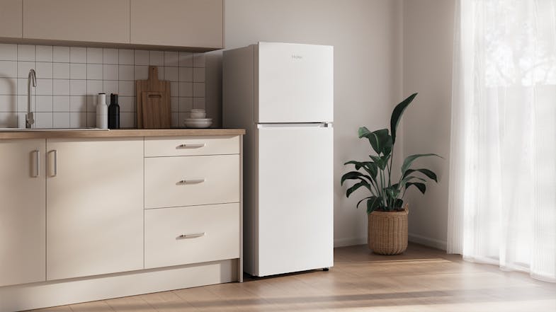 White Haier fridge in a minimalist kitchen interior White Haier fridge in a minimalist kitchen interior