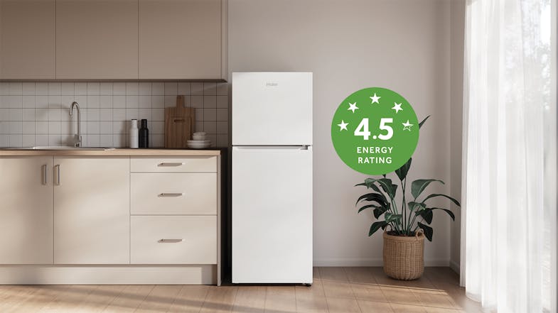 The Haier top-freezer fridge in a minimalist kitchen with a 4.5 energy rating label The Haier top-freezer fridge in a minimalist kitchen with a 4.5 energy rating label