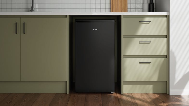 Compact black fridge positioned under green cabinetry Compact black fridge positioned under green cabinetry