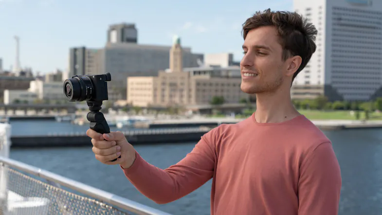 Person filming video outdoors using a grip and camera Person filming video outdoors using a grip and camera