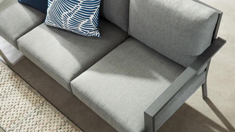 Top-down view of the grey cushioned sofa with decorative pillows Top-down view of the grey cushioned sofa with decorative pillows
