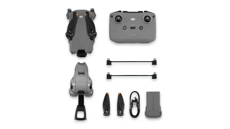 Top-down view of the DJI Mini 5 Pro drone with controller, propellers, battery, and cables Top-down view of the DJI Mini 5 Pro drone with controller, propellers, battery, and cables
