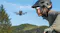 Person wearing a helmet and sunglasses watches a flying drone outdoors Person wearing a helmet and sunglasses watches a flying drone outdoors
