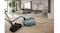 Vacuum in use on wooden floors in a modern living room with large windows Vacuum in use on wooden floors in a modern living room with large windows