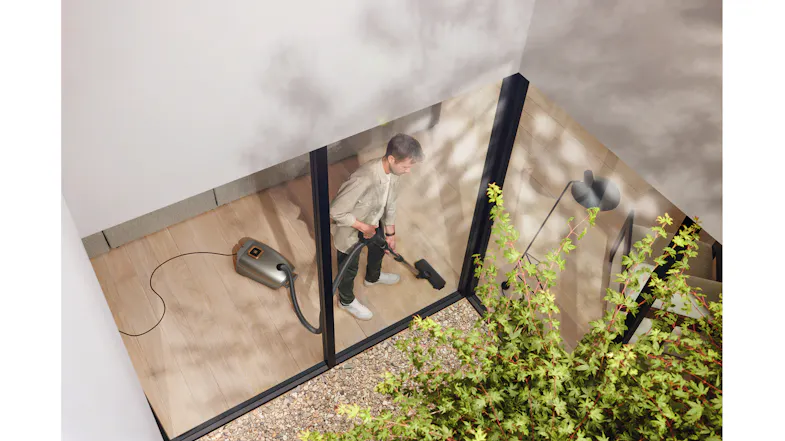 View through glass showing someone vacuuming indoors View through glass showing someone vacuuming indoors