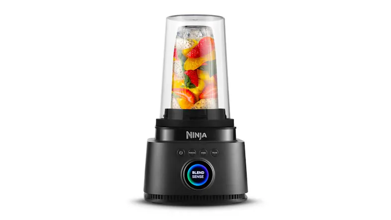 Smoothie blender upside down on base, filled with strawberries, mangoes, and fruits Smoothie blender upside down on base, filled with strawberries, mangoes, and fruits