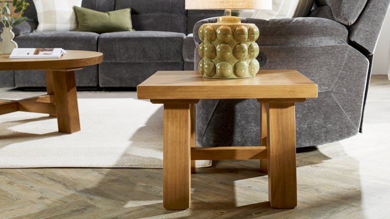 A view of a modern living room with the lamp table positioned beside a grey sofa A view of a modern living room with the lamp table positioned beside a grey sofa