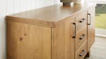 A close-up side-angle view of the buffet table showcasing its pine timber finish A close-up side-angle view of the buffet table showcasing its pine timber finish