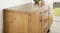 A close-up side-angle view of the buffet table showcasing its pine timber finish A close-up side-angle view of the buffet table showcasing its pine timber finish