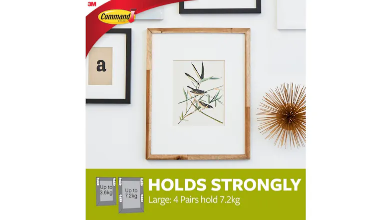 Framed artwork hung on a wall using large strips, with text noting hold up to 7.2 kg Framed artwork hung on a wall using large strips, with text noting hold up to 7.2 kg