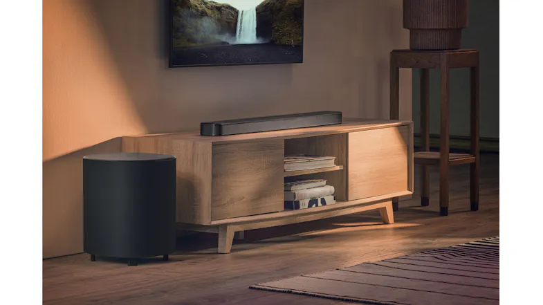 A living room setup with a black soundbar and subwoofer below a waterfall video A living room setup with a black soundbar and subwoofer below a waterfall video