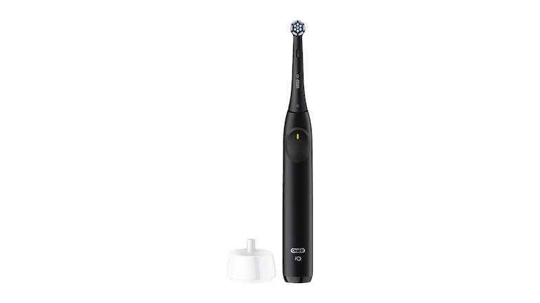 A black Oral-B iO toothbrush beside a white stand on a clean surface A black Oral-B iO toothbrush beside a white stand on a clean surface